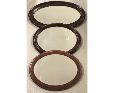 3 vintage oval shaped mirrors with mahogany coloured frames.   Largest approx. 81cm x 54cm.