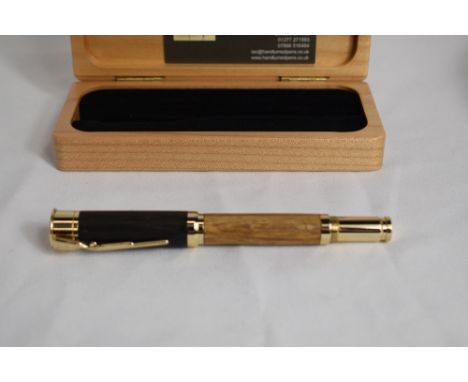 A hand turned roller pen in Bog Oak with clip in the form of a rifle and writing area in the shape of a bullet. Made by Ian D