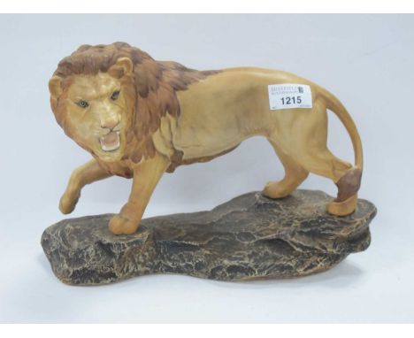 A large Beswick figure of a lion stood on a rock 21cm h.