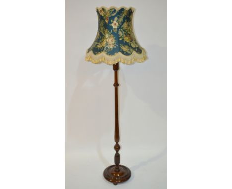 An early 20th Century mahogany standard lamp, with a turned and reeded column over a circular platform base, complete with a 
