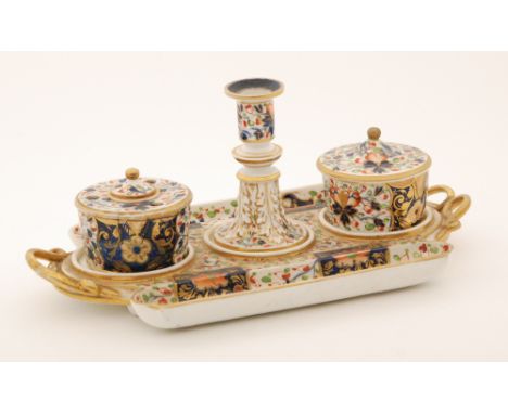 An early 19th Century Derby desk stand with three recesses to house a candlestick, covered inkwell and a cache pot, all decor