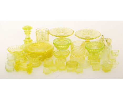 A selection of late 19th Century uranium green glass, mostly pressed tableware, to include a candlestick, a tumbler, milk jug
