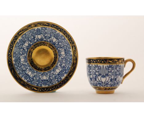 A small Royal Worcester cabinet cup and saucer decorated in the Royal Lily pattern with a blue and white pattern with gilt ed