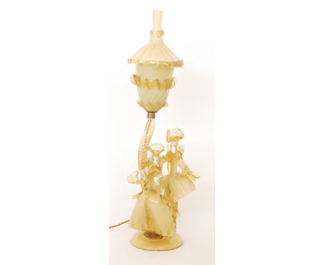 A Murano Venetian Glass Company glass lamp formed as a dandy and his beau, in amber, some cased over white, with a wrythen ar