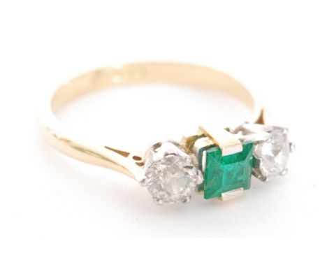 A modern 18ct hallmarked emerald and diamond three stone ring, central square cut emerald, flanked with a brilliant cut diamo