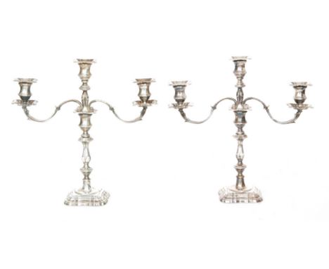 A pair of hallmarked silver three light candelabra with fixed sconces on tapering stems, knopped stem on raised foot, height 