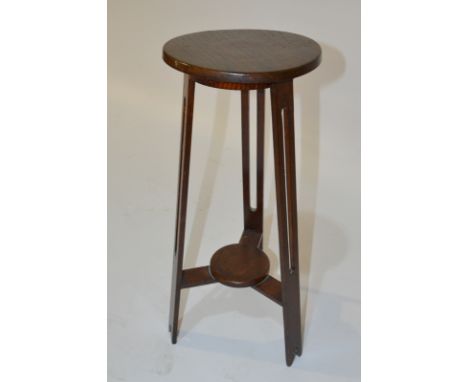 An Arts and Crafts oak jardiniere stand of circular form in the manner of Liberty &amp; Co, with fret-cut splayed supports un