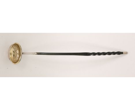 A Victorian hallmarked silver ladle, bowl embossed with floral decoration and engraved initial to base, gilt to inside of bow