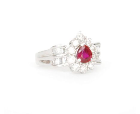 An 18ct white gold ruby and diamond cluster ring, central pear shaped ruby within a brilliant cut diamond border and baguette