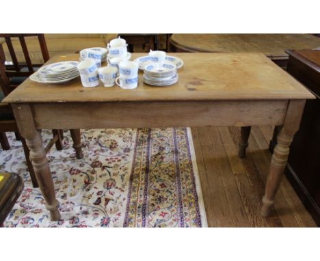 An early 20th century light oak kitchen table of oblong form with shaped top, one drawer under with brass drop handle raised 