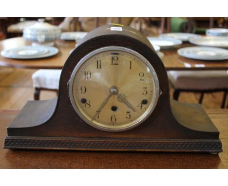 An early 20th century oak cased mantle clock with a domed top, Arabic numerals on a carved stylised base £30-50