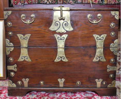 An 18th century Continental-style elm trunk or mule chest with elaborately carved brass fittings and handles, fold-down lid t