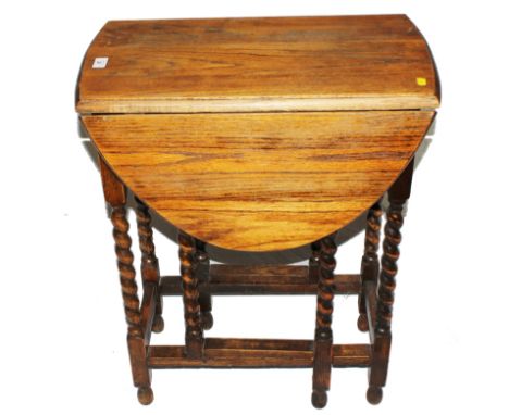 A late 19th century light oak smaller drop leaf table with gate-leg action, twin oval leaves, raised on rope twist legs, 60W 