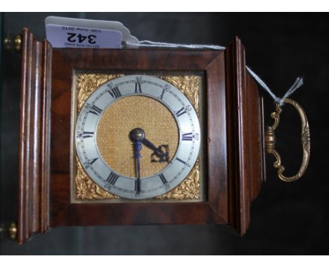 An Edwardian walnut cased mantle clock with brass handle, Roman numerals on a stepped base with brass bass with brass feet, 1