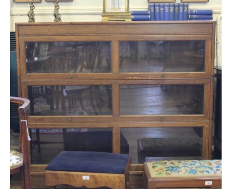 An early 20th century Globe Wernicke-style oak stained bookcase with three glazed up-and-over doors with circular brass handl