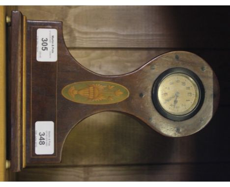 An Edwardian oak stained mantle clock with circular dial, Arabic numerals with marquetry urn decoration to the front, on oblo