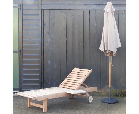 A teak garden lounger, with a drinks tray, and a loose cushion, together with a garden parasol and base