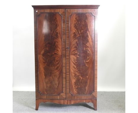 A mid 20th century bow front double wardrobe, on bracket feet, 114cm