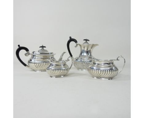 An Edwardian silver four piece tea service, of oval half gadrooned shape, comprising a teapot, 23cm long, a coffee pot, cream