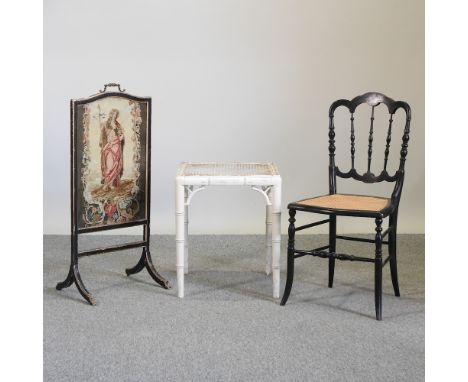 An ebonised cane seated chair, together with a white painted cane stool and an ebonised tapestry fire screen (3)