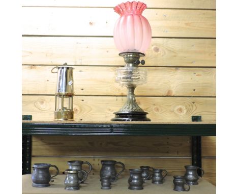 A Victorian brass oil lamp, with a ruby glass shade, 52cm high overall, together with a collection of 19th century pewter mea