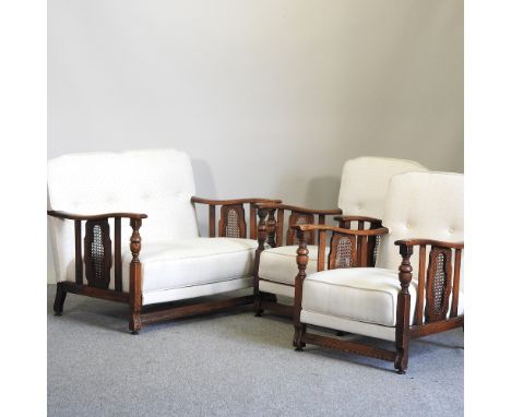 A 1920's cream upholstered single cane bergere three piece suite, to include a sofa, 106cm, and two armchairs