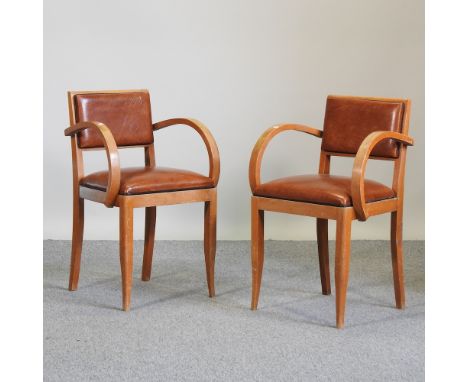 A pair of Art Deco style brown leather upholstered open armchairs