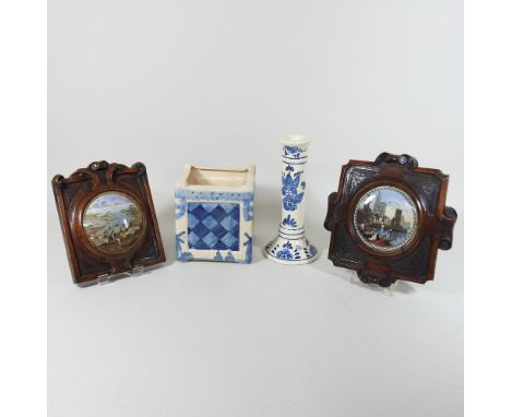 Two 19th century Pratt ware pot lids, mounted in wooden frames, together with two a Delft pot and a candlestick, 21cm high