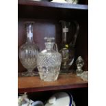 A cut glass claret jug, a cut glass decanter and stopper, and one other claret jug