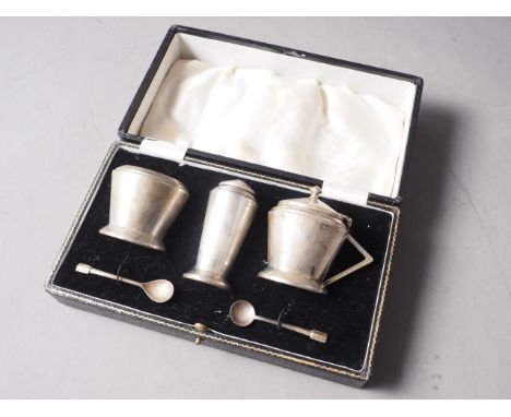 A silver Art Deco style three-piece cruet set, comprising pepper pot, salt and mustard, with blue grass liners, 5.9oz troy ap