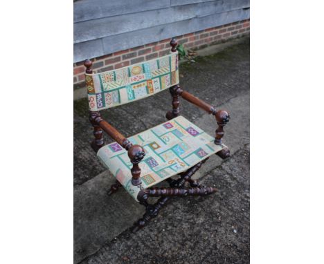 A 19th century heavily turned oak folding chair with seat and back panels in a later tapestry 