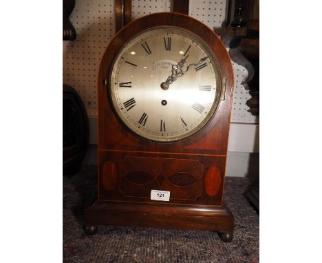 An Edwardian mahogany and line inlaid arch topped mantel clock with fusee movement, silvered dial and Roman numerals, on bras