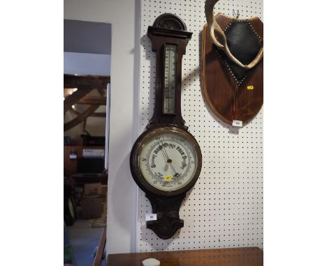 A 19th century carved oak cased aneroid barometer and thermometer, 31" high 