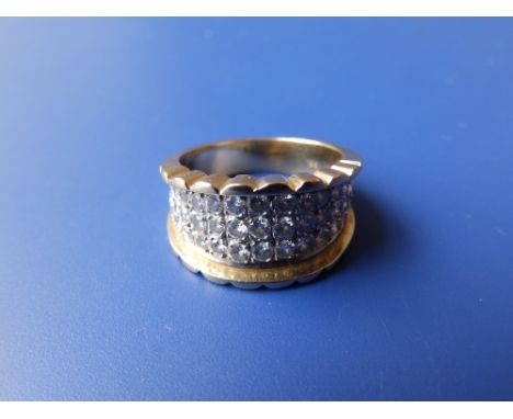 An 18K graduated band ring set with triple half rows of diamonds.  Finger size  L.
