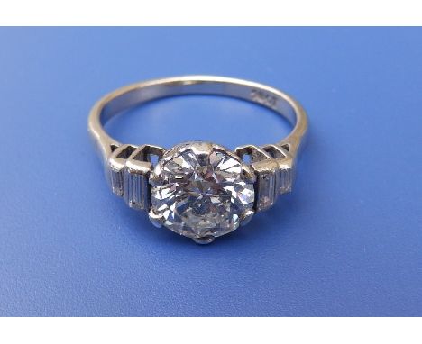 An art deco diamond solitaire ring, the claw set brilliant cut stone weighing approximately 2.4 carats flanked by four small 