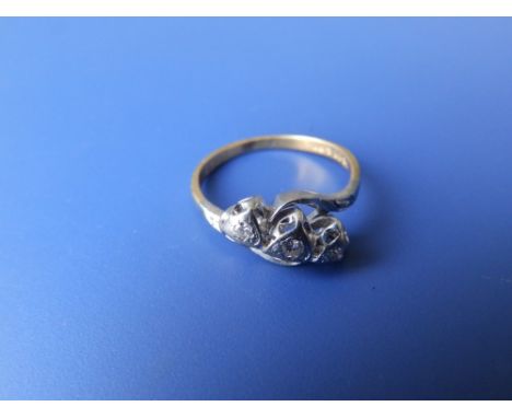 A small three stone diamond crossover style '18ct &amp; Plat' ring. Finger size L/M
