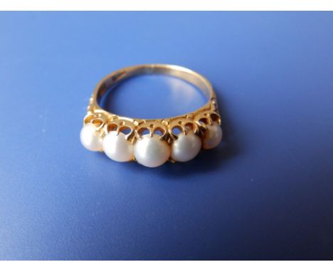 A yellow metal ring set with five graduated pearls.  Finger size O.