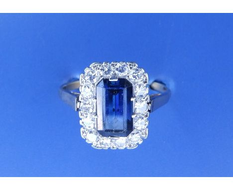 An early 20thC certified natural unheated sapphire &amp; diamond cluster ring, the emerald cut sapphire weighing approximatel