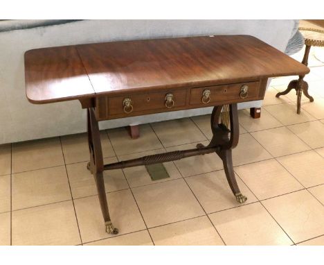 A Reproduction Mahogany Drop Leaf Sofa Table, on lion form supports, the downswept legs terminiating in brass paw caps, movin