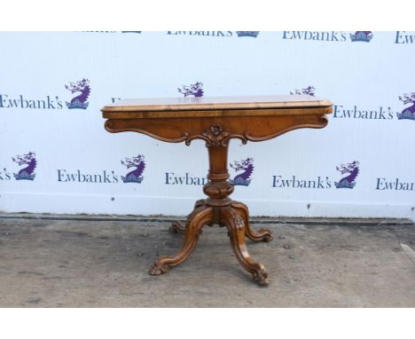 Victorian walnut card table, with circular baize lining, on turned column, on curving florally carved legs, with casters, 72c