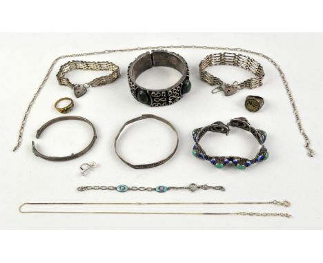 A selection of silver jewellery including two gate bracelets, two plain bangles, a bangle set with green hardstones, an ename