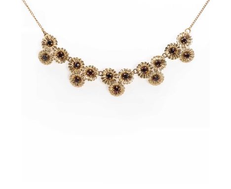 A gold garnet floral link necklace,with gold floral trefoil links, with circular cut garnets four claw set to each flower hea