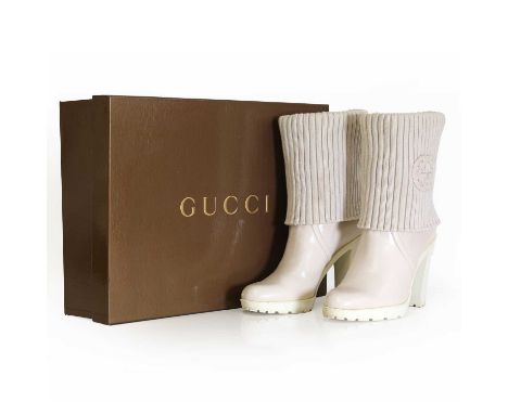 A pair of Gucci cream leather boots,with rubber soles and knitted fold over top with leather GG logo to side, with dust bag a