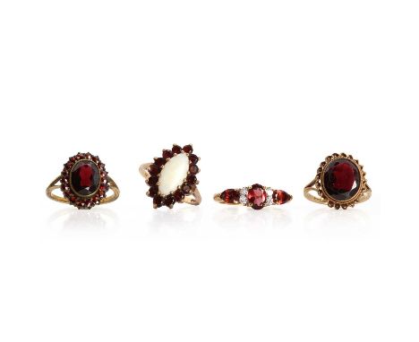 A group of four garnet rings,comprising two 9ct gold garnet rings, the first with a marquise shaped opal cabochon claw set to