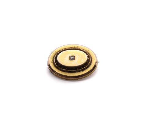 A Victorian gold diamond memorial brooch,a central old European cut diamond, grain set to a hollow gold oval stepped shield w
