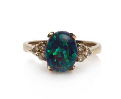 A 9ct gold synthetic black opal and diamond ring,a synthetic black opal oval cabochon claw set to the centre, with a diamond 