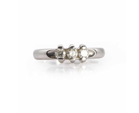 A white gold three stone diamond ring, three round brilliant cut diamonds bar set to the concave ring head, to solid shoulder