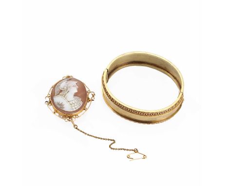 A gold hinged bangle,the oval polished bangle of uniform 19mm width with applied wirework and ropetwist embelishment to the f