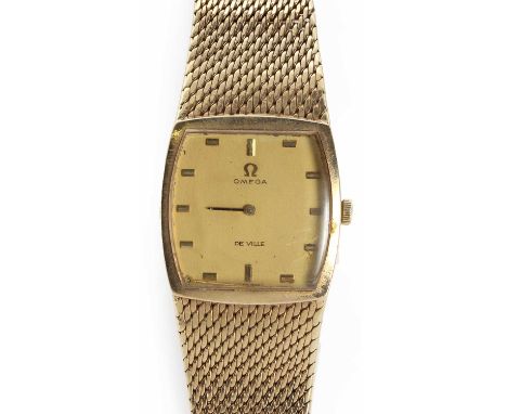 A gentlemen's 9ct gold Omega De Ville mechanical bracelet watch,a plain gold tonneau shaped case, 28mm x 30mm, with a gilt di