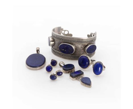 A collection of silver lapis lazuli jewellery,comprising an ornate torque bangle with three large flat top cabochon lapis laz